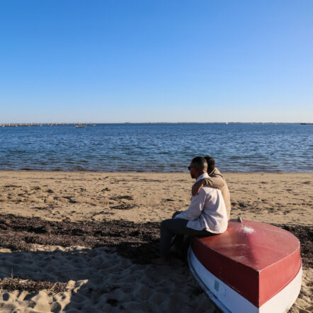 Couple sitting on a boat by the beach