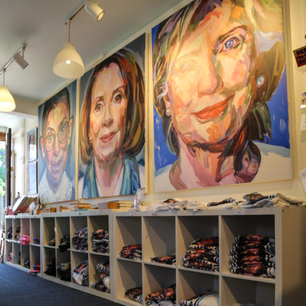 Art shop with large portraits and folded shirts on display