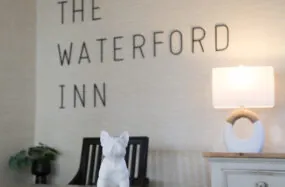 Lobby front desk fiew with The Waterfird Inn sign, lamp and dog statue on table