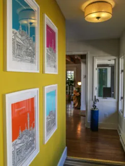 Colorful farmed art on a yellow wall in lobby hallway