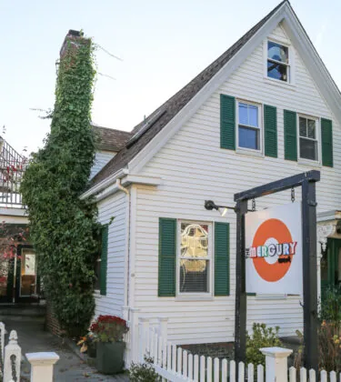Exterior of Mercury with white siding, green shutters and front sign