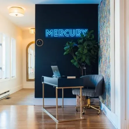 Front desk area with neon Mercury sign and modern decor