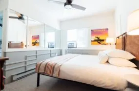 Guest room with large windows, standard king bed and airplane wall art