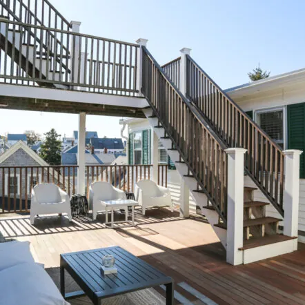 Outdoor deck with white chairs and wooden stairs at Mercury Hotel