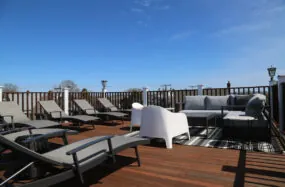Rooftop deck with lounge chairs and seating under sunny day
