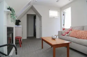 Bright sitting area with sofa, coffee table and sloped ceiling